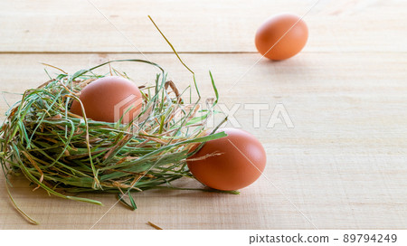 Natural easter colour eggs in basket with spring tulips, white feathers on wooden table background in Happy Easter decoration. Spring holiday concept. 89794249