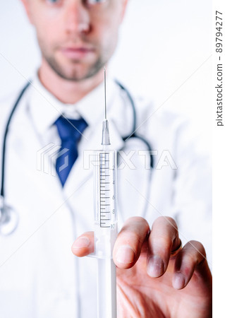 Syringe needle medical injection. Selective focus, doctor hand in blue gloves holding syringe with needle. Hospital white doctor gown, stethoscope. Syringe with flu vaccine with copy space. Syringe needle medical injection. Selective focus, doctor hand in blue gloves holding syringe with needle. Hospital white doctor gown, stethoscope. Syringe with flu vaccine with copy space. 89794277