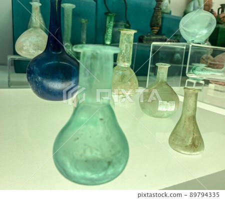 ancient glass flasks for mixing chemical and natural reagents. excursion to the museum. exhibits of the ancient world. transparent and blue flasks 89794335