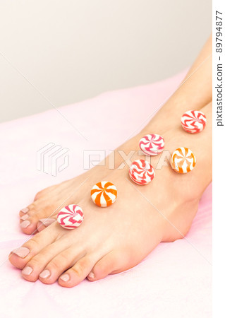 Depilation, waxing concept. Round candies lying down in a row on the female leg, close up Depilation, waxing concept. Round candies lying down in a row on the female leg, close up 89794877
