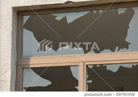 Broken window of abandoned building 89795398