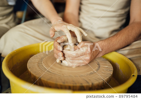 Hands of a potter. Potter making ceramic pot on the pottery wheel Hands of a potter. Potter making ceramic pot on the pottery wheel 89795484