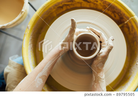 Hands of a potter. Potter making ceramic pot on the pottery wheel 89795505