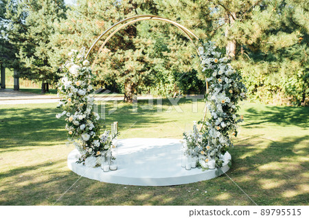 Very beautiful outside ceremony. classical wedding in forest. Metal arch with flowers. 89795515
