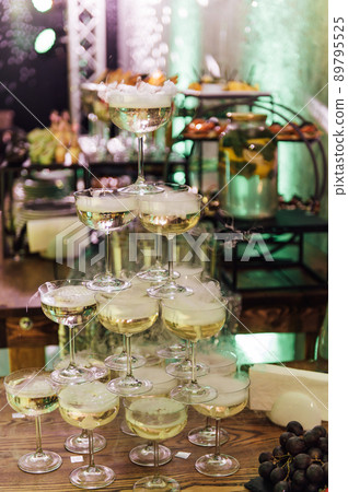 Champagne glasses standing in a tower at the party Champagne glasses standing in a tower at the party 89795525
