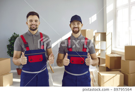 Two happy delivery company workers guaranteeing best service and showing thumbs up Two happy delivery company workers guaranteeing best service and showing thumbs up 89795564