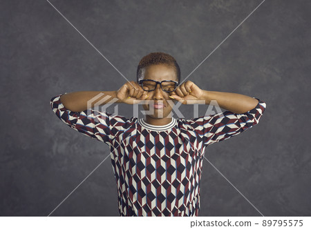 Capricious dissatisfied and upset African American woman with a frowning face cries. 89795575