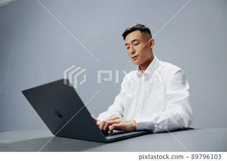 manager sits at a desk in front of a laptop executive manager sits at a desk in front of a laptop executive 89796103