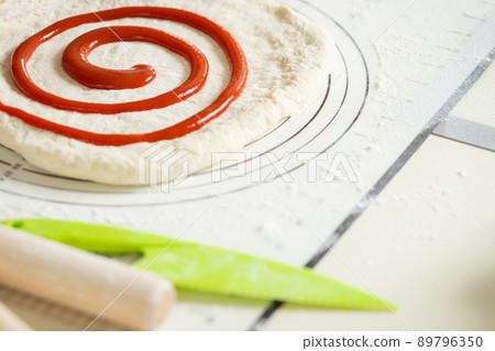 Berry jam spirally applied to rolled out dough for a sweet dessert roll 89796350