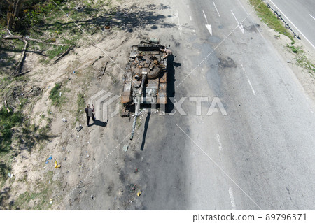 Kyiv region, Ukraine - May 15, 2022: War in Ukraine. Highway Kyiv - Zhytomyr. People take selfies against destroyed russian tank after russian atack in Febrary. Kyiv region, Ukraine - May 15, 2022: War in Ukraine. Highway Kyiv - Zhytomyr. People take selfies against destroyed russian tank after russian atack in Febrary. 89796371