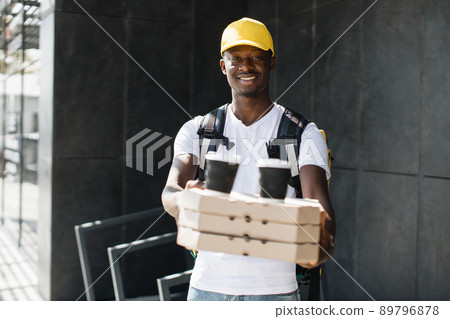 African courier delivering boxes with pizza and hot coffee. African courier delivering boxes with pizza and hot coffee. 89796878