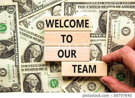 Welcome to our team symbol. Concept words Welcome to our team on wooden blocks. Businessman hand. Beautiful background from dollar bills. Business, motivational and welcome to our team concept. 89797640