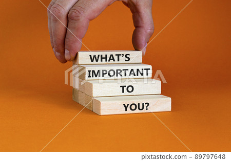 What is important to you symbol. Concept words What is important to you on blocks. Businessman hand. Beautiful orange table orange background. What is important to you business concept. Copy space. 89797648