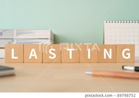 Permanent and long-lasting image | Desk with building blocks with "LASTING" written on it 89798752