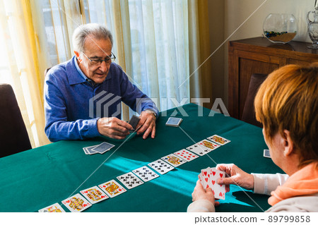Grandparent's playing a card game in home 89799858