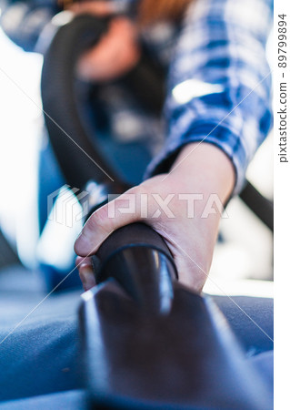 close-up shot of a young woman's hand with a car hoover 89799894