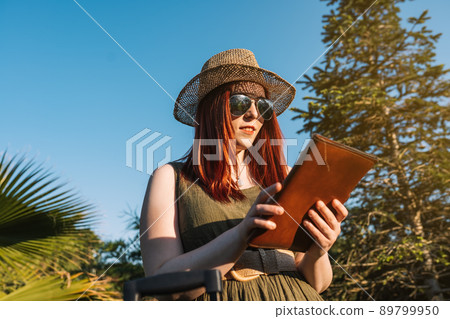 young woman with hipster style enjoying her summer holidays. weekend. female redhead planning her next trip. young woman with hipster style enjoying her summer holidays. weekend. female redhead planning her next trip. 89799950