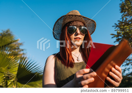 young woman with hipster style enjoying her summer holidays. weekend. female redhead planning her next trip. 89799951