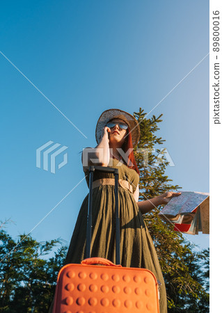 young red-haired girl calling with her smart phone for a taxi to pick her up at her resort. travel, summer holiday, young red-haired girl calling with her smart phone for a taxi to pick her up at her resort. travel, summer holiday, 89800016
