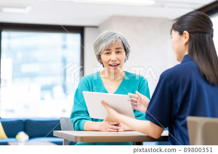 Middle-aged woman consulting a care manager for long-term care Middle-aged woman consulting a care manager for long-term care 89800351