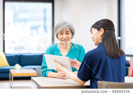 Middle-aged woman consulting a care manager for long-term care 89800356