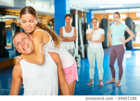 Young woman practicing self defence techniques with coach Young woman practicing self defence techniques with coach 89801386