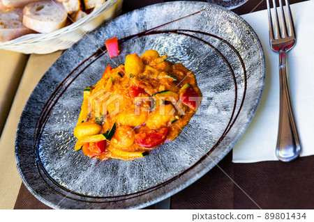 Tasty dumplings from salmon and stewed zucchini and tomatoes 89801434