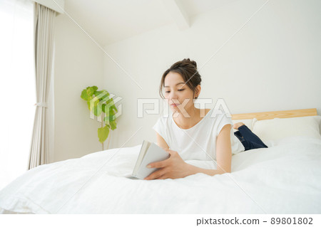 A woman relaxing in bed 89801802