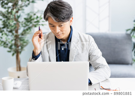 一個商人在帶沙發的明亮房間裡做辦公桌工作 89801881