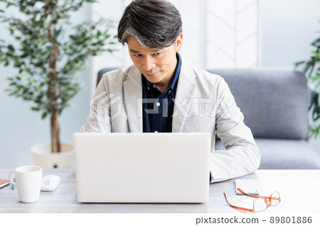 一個商人在帶沙發的明亮房間裡做辦公桌工作 一個商人在帶沙發的明亮房間裡做辦公桌工作 89801886