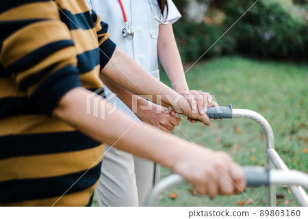 Nurse helping elderly woman hands holding walker trying to walking at outdoor,Care nursing home concept,Physical therapy 89803160