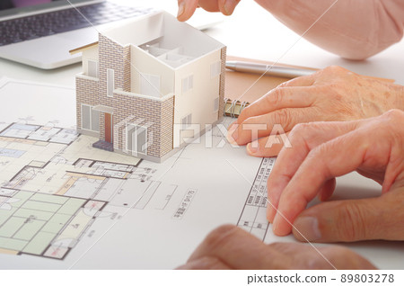 Senior couple considering while looking at the drawing of the house Senior couple considering while looking at the drawing of the house 89803278