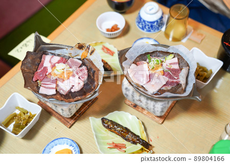 Japanese pork grill style on the traditional stove with local dry leaf and appetizer around. Japanese pork grill style on the traditional stove with local dry leaf and appetizer around. 89804166