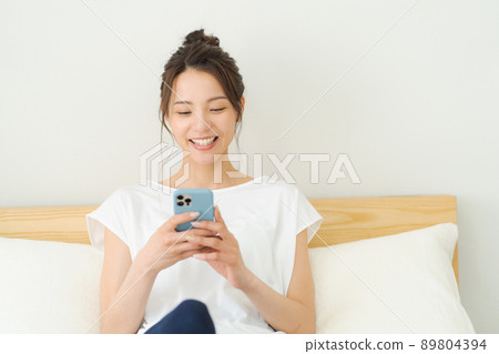 A woman relaxing in bed A woman relaxing in bed 89804394