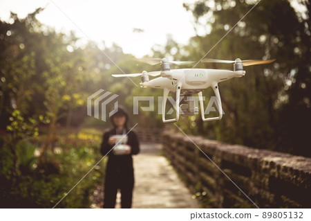 People remote control a flying drone People remote control a flying drone 89805132