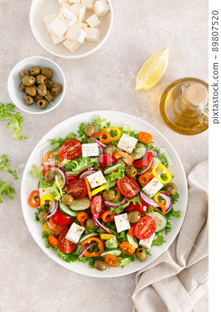 Greek salad with feta cheese, tomatoes, cucumbers, pepper, red onion and green olives. Top view Greek salad with feta cheese, tomatoes, cucumbers, pepper, red onion and green olives. Top view 89807520