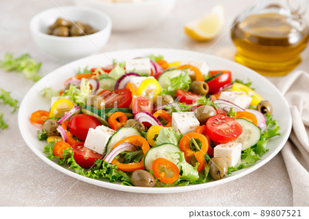 Greek salad with feta cheese, tomatoes, cucumbers, pepper, red onion and green olives. Top view Greek salad with feta cheese, tomatoes, cucumbers, pepper, red onion and green olives. Top view 89807521