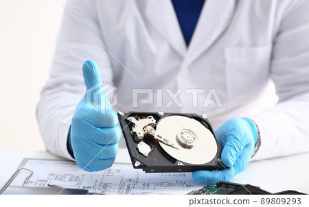Man in uniform hold disassembled hard drive from computer, hdd and reader, show thumbs up Man in uniform hold disassembled hard drive from computer, hdd and reader, show thumbs up 89809293