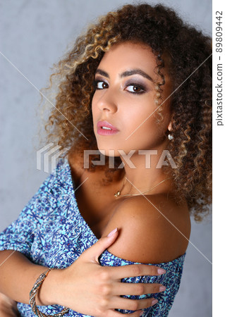 Stunning latin woman with curly hair posing in professional studio, latinoamerican woman work for model agency 89809442