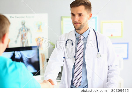 Specialist greeting colleague, friendly handshake gesture, intelligent doctor wear medical uniform Specialist greeting colleague, friendly handshake gesture, intelligent doctor wear medical uniform 89809455