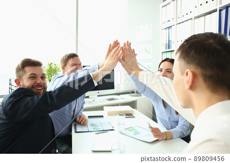 Colleagues give high five in order to celebrate successful contract, good news Colleagues give high five in order to celebrate successful contract, good news 89809456
