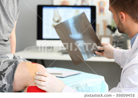 Physician doctor examining patient leg, hold x ray of bone, injury after accident Physician doctor examining patient leg, hold x ray of bone, injury after accident 89809458