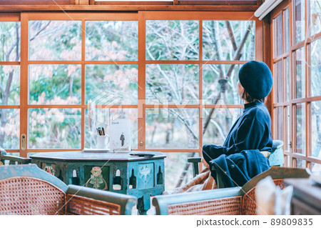 A woman looking out of an old folk house 89809835