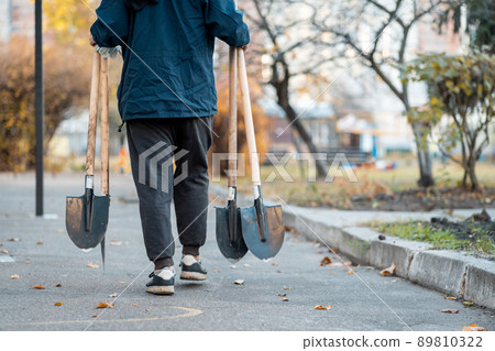 planting new trees with gardening tools or male volunteer carry shovels outdoor 89810322