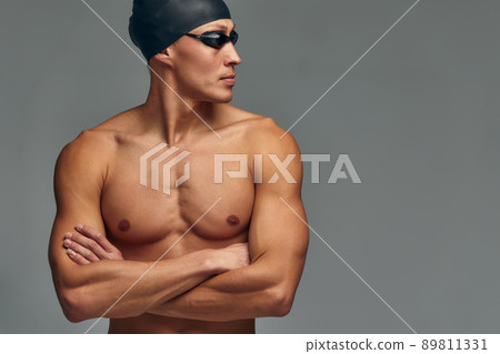 Portrait of a swimmer in a cap and mask, half-length portrait, young athlete swimmer wearing a cap and mask for swimming, copies of space, gray background. Portrait of a swimmer in a cap and mask, half-length portrait, young athlete swimmer wearing a cap and mask for swimming, copies of space, gray background. 89811331