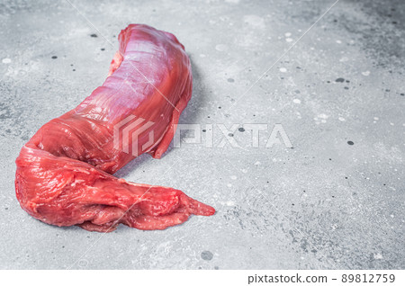 Whole piece of raw beef tenderloin on butcher table. Gray background. Top view. Copy space 89812759