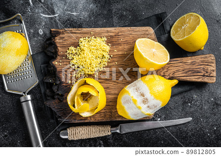 Grated Lemon Zest and spiral peel on wooden board. Black background. Top view Grated Lemon Zest and spiral peel on wooden board. Black background. Top view 89812805