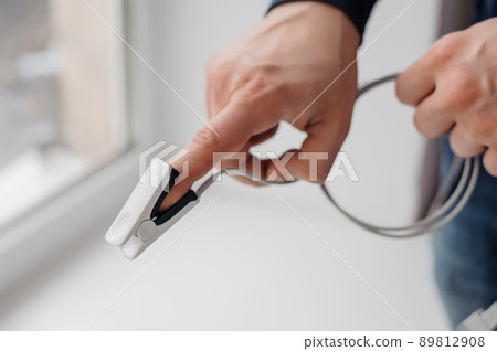 Pulse oximeter on a white background. Medical monitoring and diagnostic device for non-invasive measurement of capillary blood oxygen saturation Pulse oximeter on a white background. Medical monitoring and diagnostic device for non-invasive measurement of capillary blood oxygen saturation 89812908