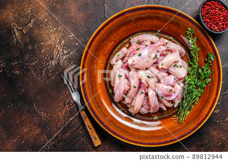 Cut Raw Chicken breast fillet on a plate. Dark background. Top view. Copy space 89812944