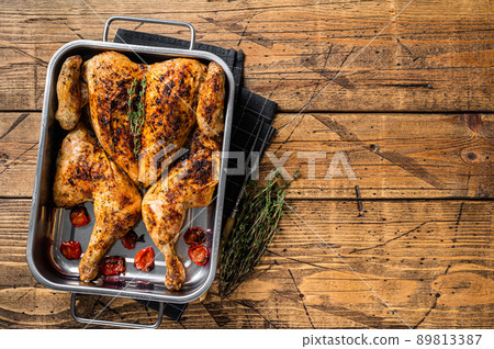 Homemade chicken rotisserie with thyme in baking dish. Wooden background. Top view. Copy space Homemade chicken rotisserie with thyme in baking dish. Wooden background. Top view. Copy space 89813387